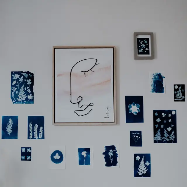 A wall of blue cyanotype fern prints around a line drawing