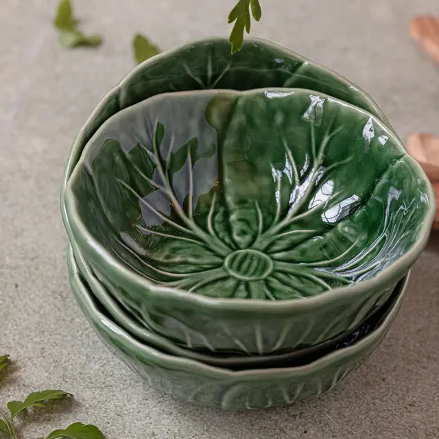 Three stacked green glazed ceramic bowls with leaf texture